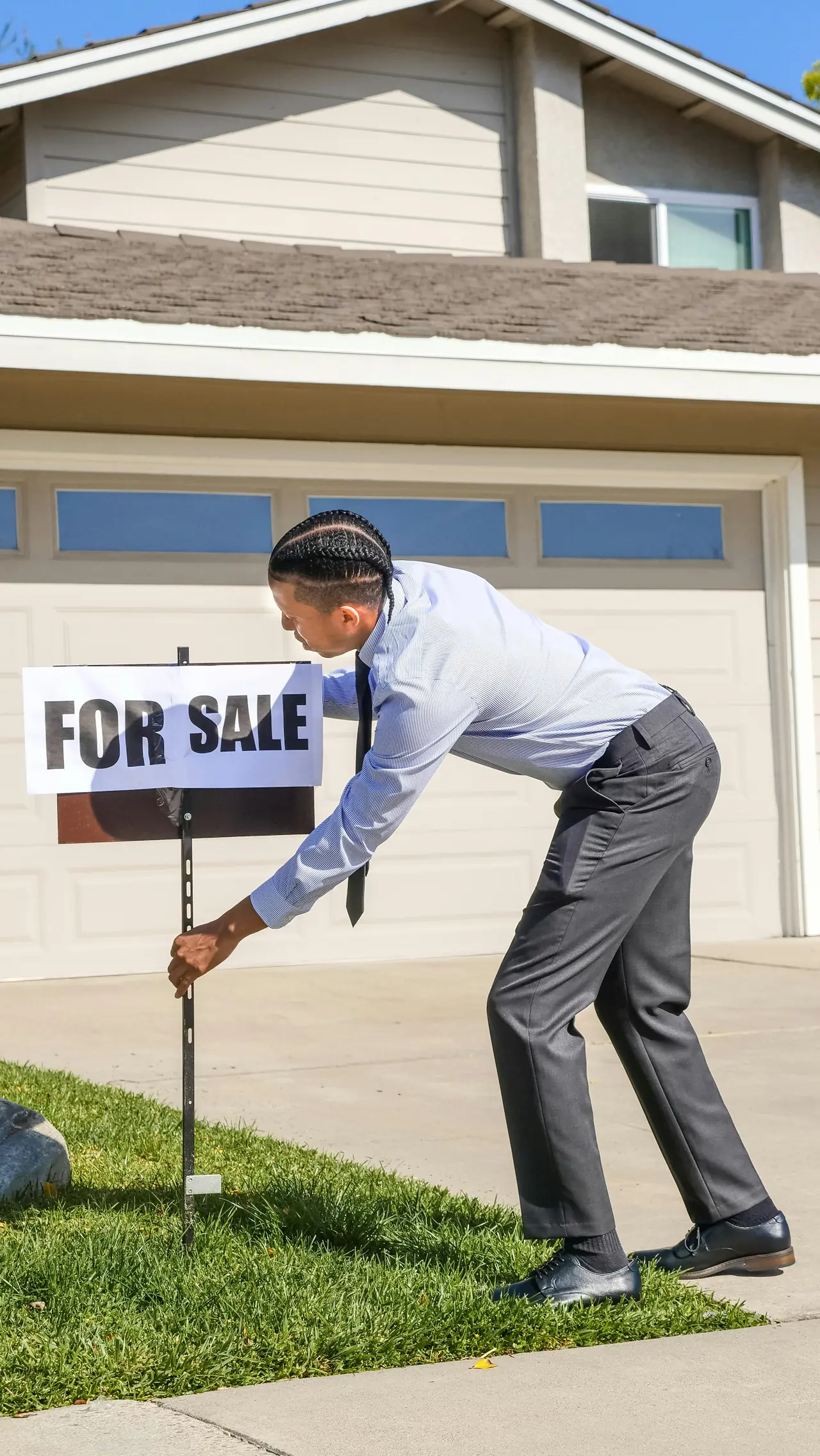 Installer setting a For Sale sign post in a front lawn